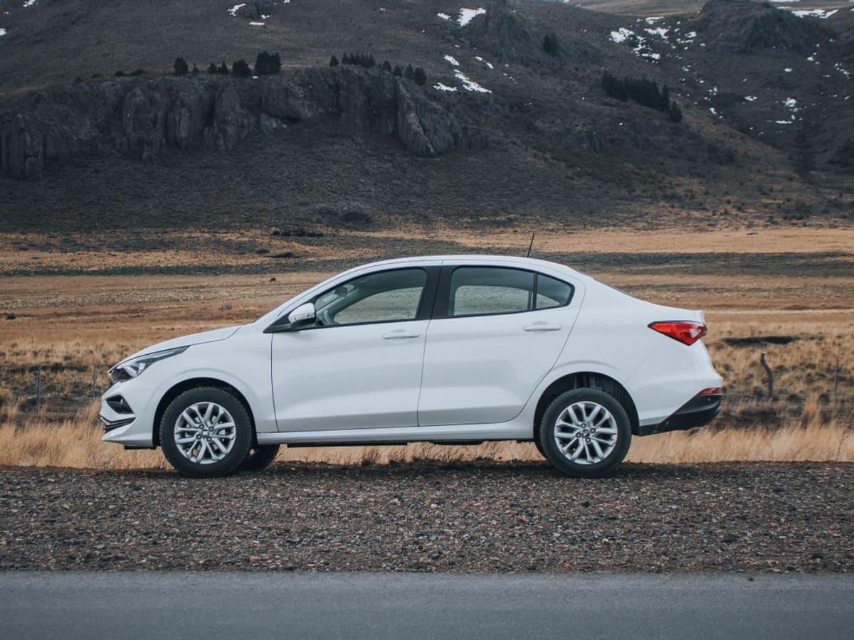 White compact sedan parked by an open road