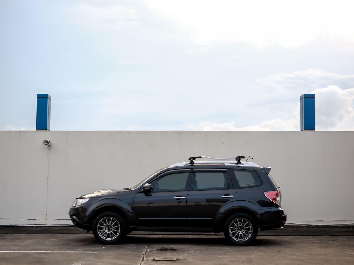 Black SUV parked in front of a white wall